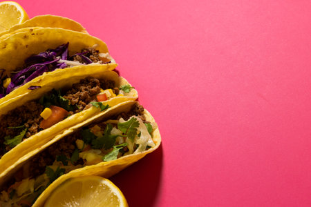 High angle view of tacos with lemon slices over pink background, copy space. vegetable, meat, tortilla, food, fresh and mexican food concept.の写真素材