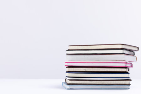 Close up of stack of books and notebooks with copy space on white background. Reading, learning,...