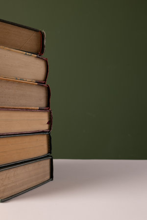 Close up of stack of books with copy space on green background. Reading, learning, school and education concept.の写真素材