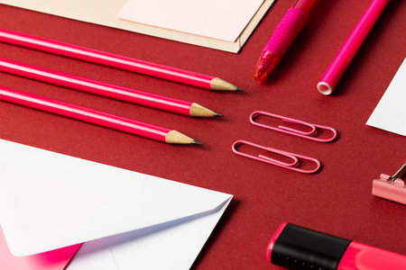 Flat lay of white papers with copy space and school materials on red background. School materials, writing, colouring, drawing, learning, school and education concept.の写真素材