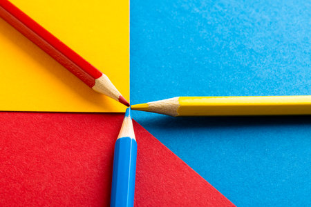 Close up of red, yellow and blue pencils with copy space on red, yellow and blue background. School materials, writing, colouring, drawing, learning, school and education concept.の写真素材