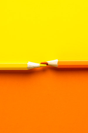 Close up of orange and yellow pencils with copy space on orange and yellow background. School materials, writing, colouring, drawing, learning, school and education concept.の写真素材