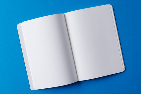Close up of open book with copy space on blue background. Literature, reading, writing, leisure time...