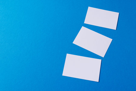 White business cards with copy space on blue background. Business, business card, stationery and writing space digitally generated image.の写真素材
