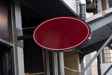Blank oval sign fixed to building wall with copy space. Signage, writing space and street signs concept.の写真素材