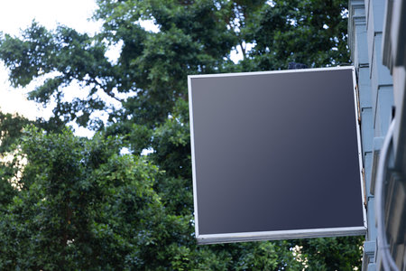 Blank sign fixed to building wall with copy space. Signage, writing space and street signs concept.の写真素材