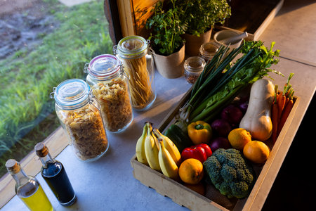Crate of organic vegetables on countertop in sunny kitchen in log cabin. Food, nutrition, balanced...