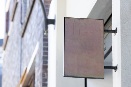 Blank sign fixed to building wall with copy space. Signage, writing space and street signs concept.の写真素材