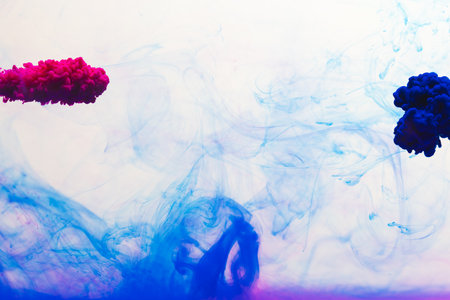 Close up of blue and pink ink in water with copy space on white background. Ink, liquid, shape and colour concept.の写真素材