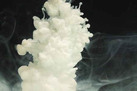 Close up of white ink in water with copy space on black background. Ink, liquid, shape and colour concept.の写真素材
