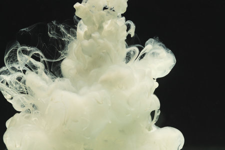 Close up of white ink in water with copy space on black background. Ink, liquid, shape and colour concept.の写真素材