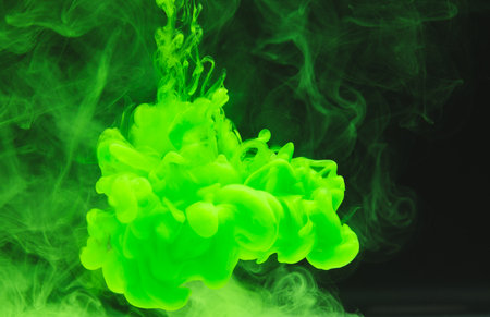 Close up of bright green ink in water with copy space on black background. Ink, liquid, shape and colour concept.の写真素材