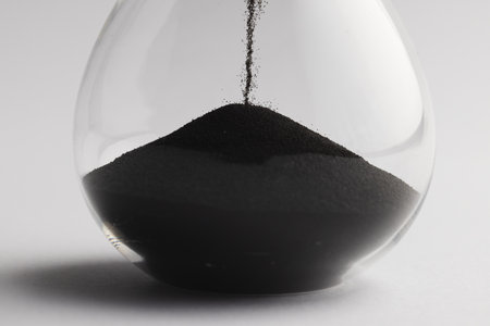 Close up of hourglass with black sand and copy space on white background. Time, timekeeping, shape...