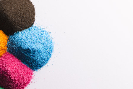 Close up of heaps of multi coloured sand and copy space on white background. Sand, texture,...