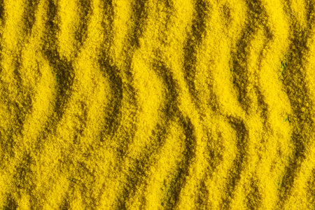 Close up of pattern of yellow sand and copy space background. Sand, texture, movement, shape and...