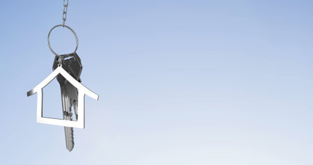 Image of silver house keys against copy space on blue gradient background. Relocation and real...