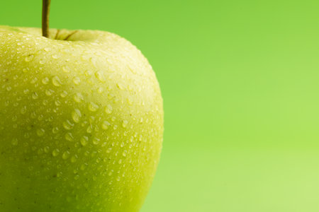 Close up of green apple and copy space on green background. Fruit, food, freshness and colour concept.の写真素材