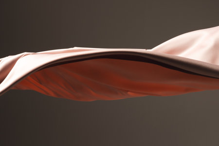 Close up of pink shiny silk fabric with copy space on black background. Texture, fabric, cloth, colour and material.の写真素材