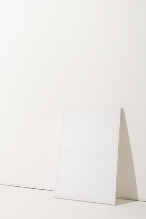 White canvas and copy space leaning against white wall background. Signage, writing space and advertising concept.の写真素材