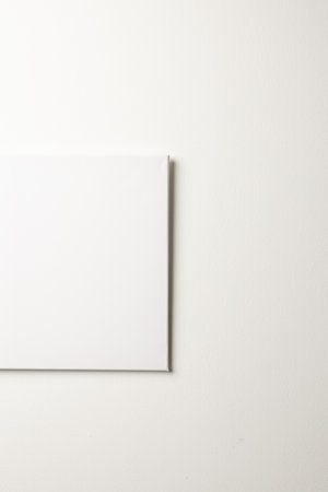 White canvas and copy space hanging in white wall background. Signage, writing space and advertising concept.の写真素材