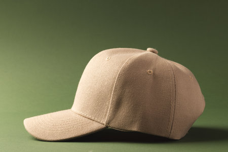 Cream baseball cap and copy space on green background. Fashion, clothes, colour and fabric concept.の写真素材