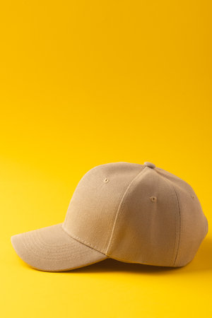 Cream baseball cap and copy space on yellow background. Fashion, clothes, colour and fabric concept.の写真素材