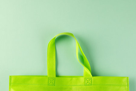 Green canvas bag with copy space on green background. Shopping, bag, colour, fabric, texture and materials concept.の写真素材