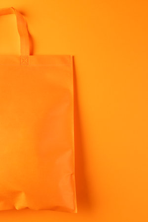 Close up of orange canvas bag with copy space on orange background. Shopping, bag, colour, fabric, texture and materials concept.の写真素材