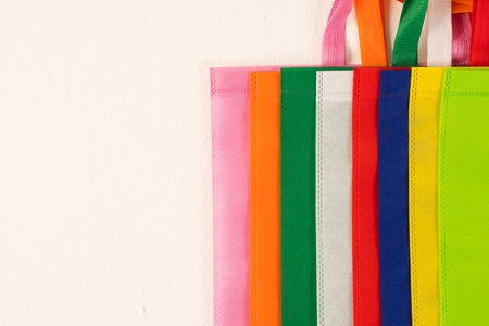Row of multi colour canvas bags with copy space on white background. Shopping, bag, colour, fabric, texture and materials concept.の写真素材