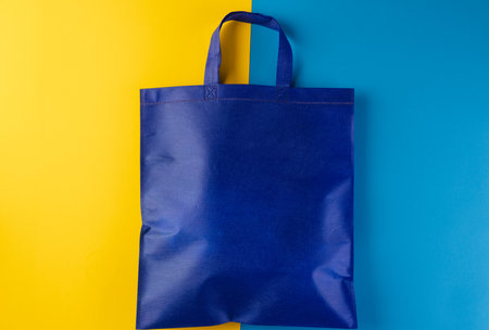Close up of blue canvas bag with copy space on yellow and blue background. Shopping, bag, colour, fabric, texture and materials concept.の写真素材