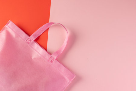 Pink canvas bag with copy space on pink and red background. Shopping, bag, colour, fabric, texture and materials concept.の写真素材