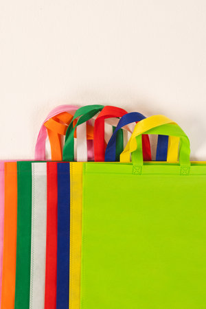 Row of multi colour canvas bags with copy space on white background. Shopping, bag, colour, fabric, texture and materials concept.の写真素材