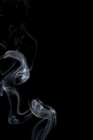 White clouds of smoke with copy space on black background. Halloween, colour, movement and smoke concept.の写真素材