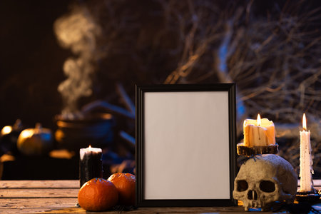 Black frame with copy space, skull, candles and smoke on black background. Halloween, colour, movement and smoke concept.の写真素材