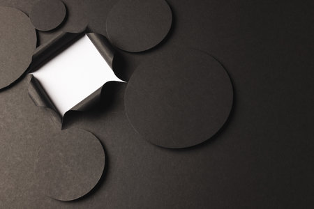 Circles of black paper with copy space and square opening on white background. Paper, writing, texture and materials concept.の写真素材
