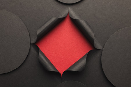 Circles of black paper with copy space and square opening on red background. Paper, writing, texture and materials concept.の写真素材