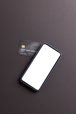 Vertical image of smartphone with blank screen and credit card on black background. Cyber monday, cyber shopping, retail, technology, electronic device and communication concept.の写真素材