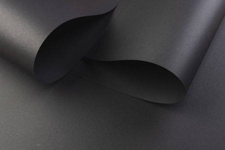 Close up of layers of pieces of black paper with copy space on black background. Paper, writing, texture and materials concept.の写真素材