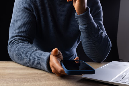 Biracial businessman using smartphone and laptop on grey background. Technology, digital networks,...