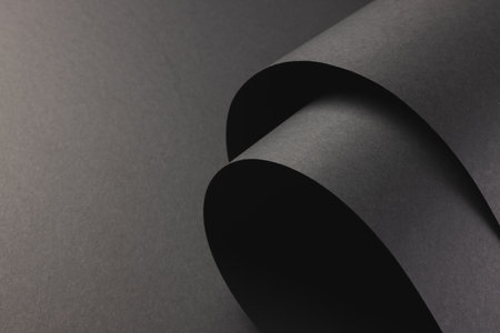 Close up of layers of pieces of black paper with copy space on black background. Paper, writing,...