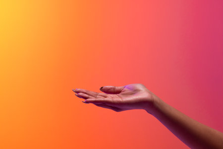 Hand of biracial woman with copy space on neon red to orange background. Technology, digital networks, global connections and communication metaverse.の写真素材