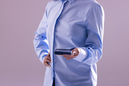 Biracial businesswoman using smartphone with copy space on grey background. Technology, digital networks, global connections and communication metaverse.の写真素材