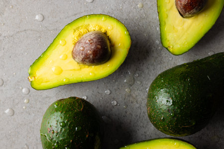 Micro close up of avocados with water drops and copy space on grey background. Micro photography,...