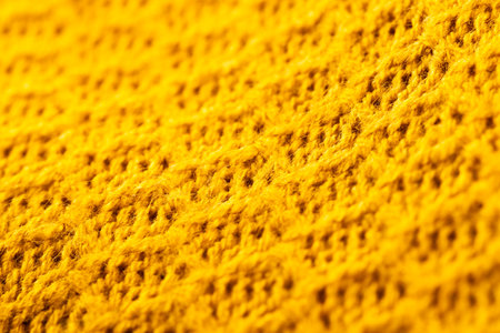 Micro close up of yellow crocheted woolly fabric with copy space. Micro photography, fabric, pattern, texture and colour concept.の写真素材