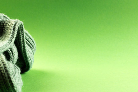 Micro close up of green wooly crochet fabric with copy space on green background. Micro photography, fabric, pattern, texture and colour concept.の写真素材