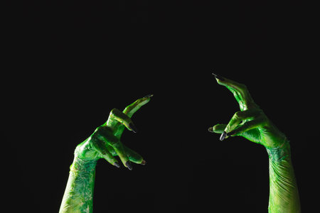 Green monster hands with black nails reaching on black background. Halloween, tradition and celebration concept.の写真素材
