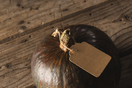 Pumpkin with tag with copy space on brown background. Fall, autumn, halloween, tradition and celebration concept.の写真素材