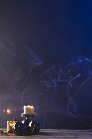 Vertical image of pumpkin, skulls and candles with copy space on dark background. Fall, autumn, halloween, tradition and celebration concept.の写真素材