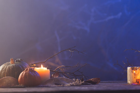 Pumpkins and candles with copy space on blue background. Fall, autumn, halloween, tradition and celebration concept.の写真素材