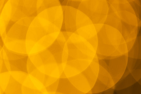 Multiple yellow bokeh lights with copy space on yellow background. Light, colour and shape concept digitally generated image.の写真素材